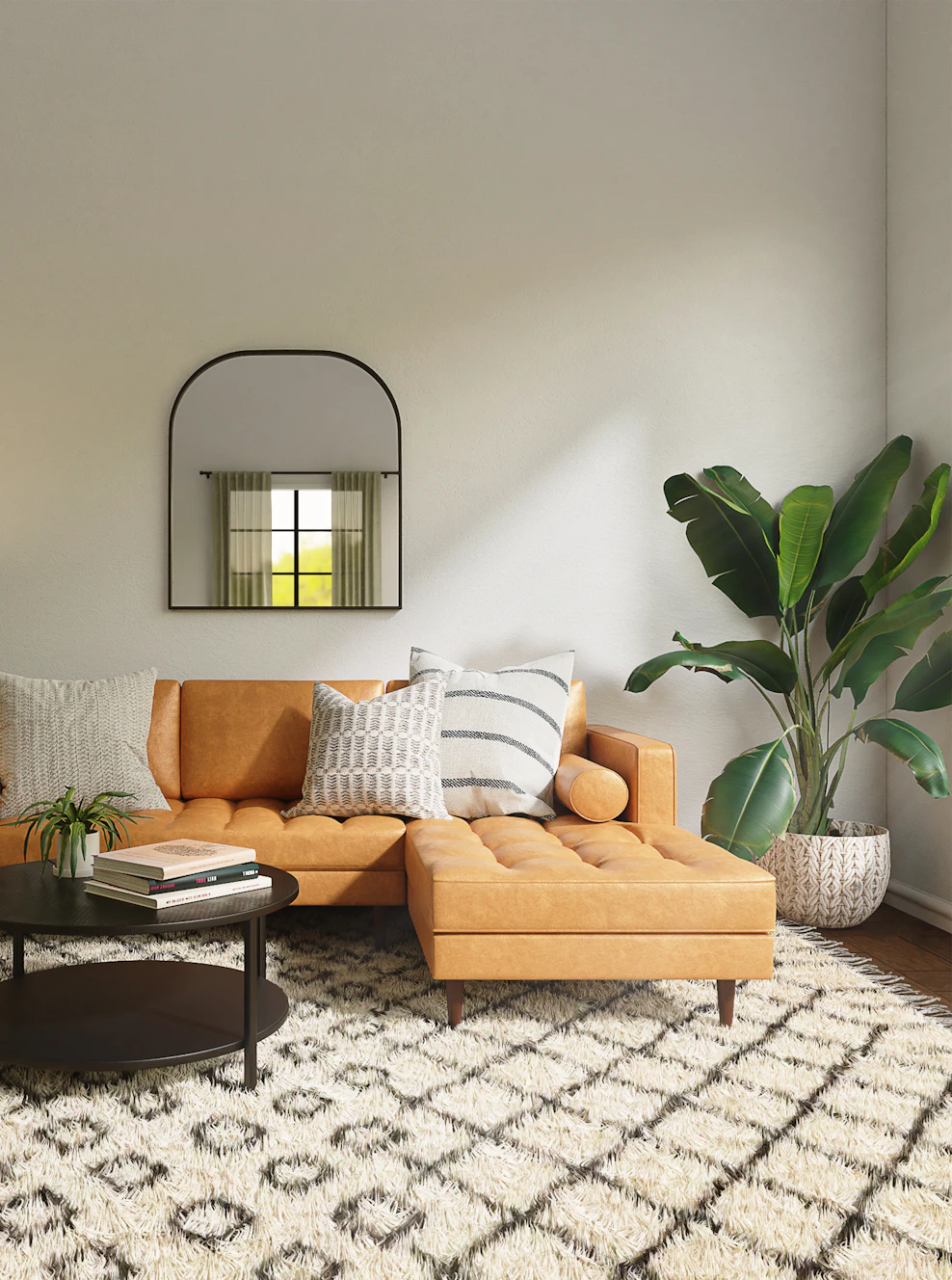 Living room with a tan leather sofa, patterned rug and a tall plant – The Design Organization