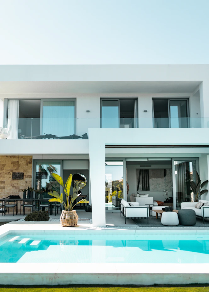 White modern villa with a swimming pool and outdoor lounge – The Design Organization