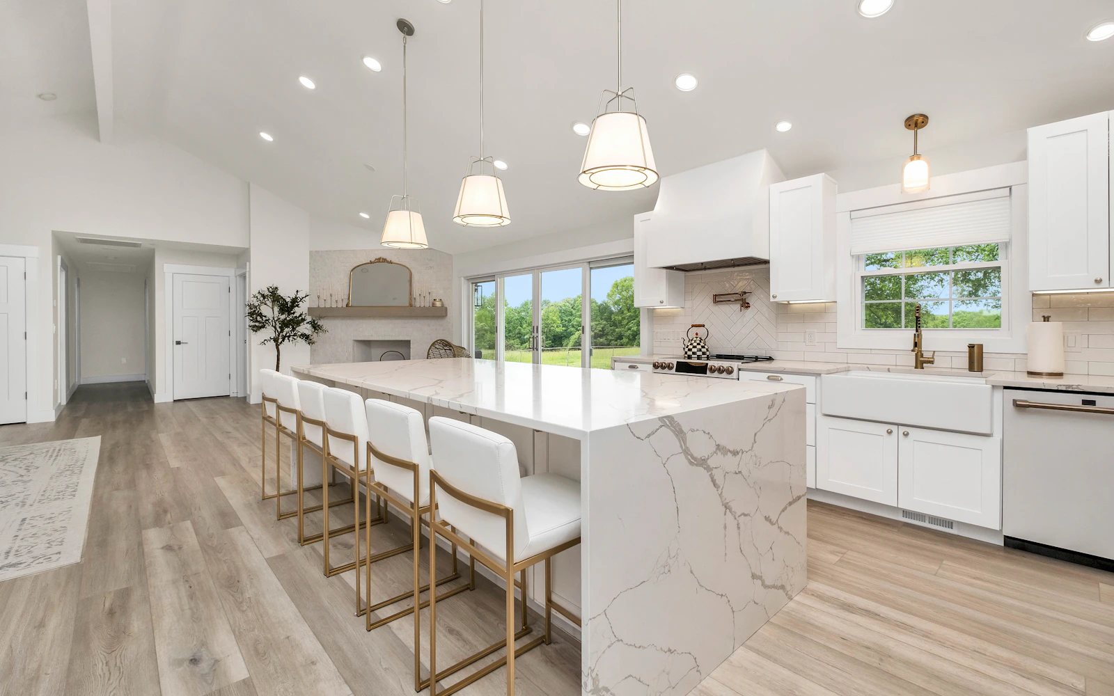 Kitchen with a marble island and white cabinets – The Design Organization